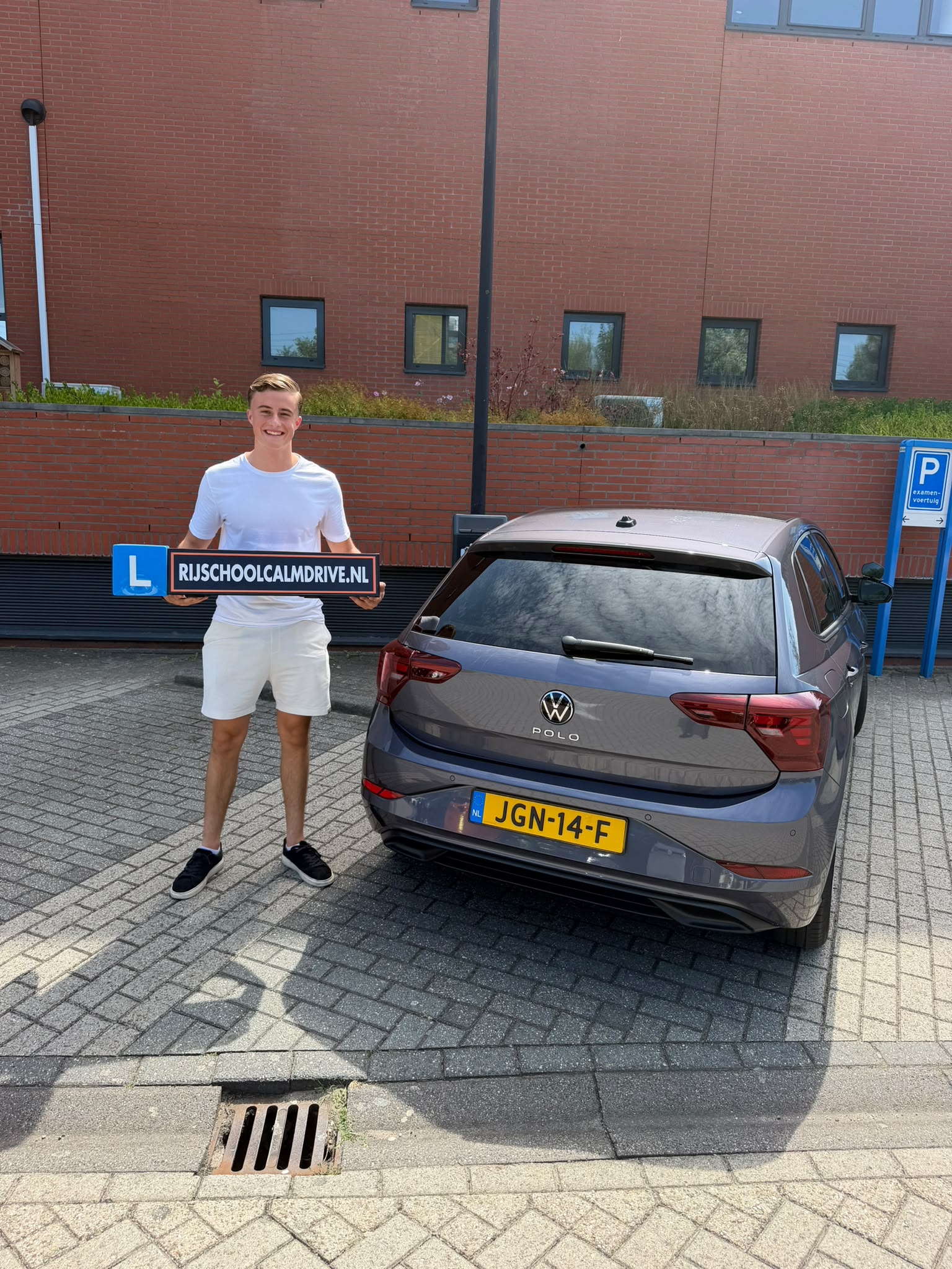Geslaagde leerling met L-bord bij Calm Drive lesauto